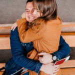 Man sitting on a bench with a woman on his lap as a symbol of how long-distance relationships can work.
